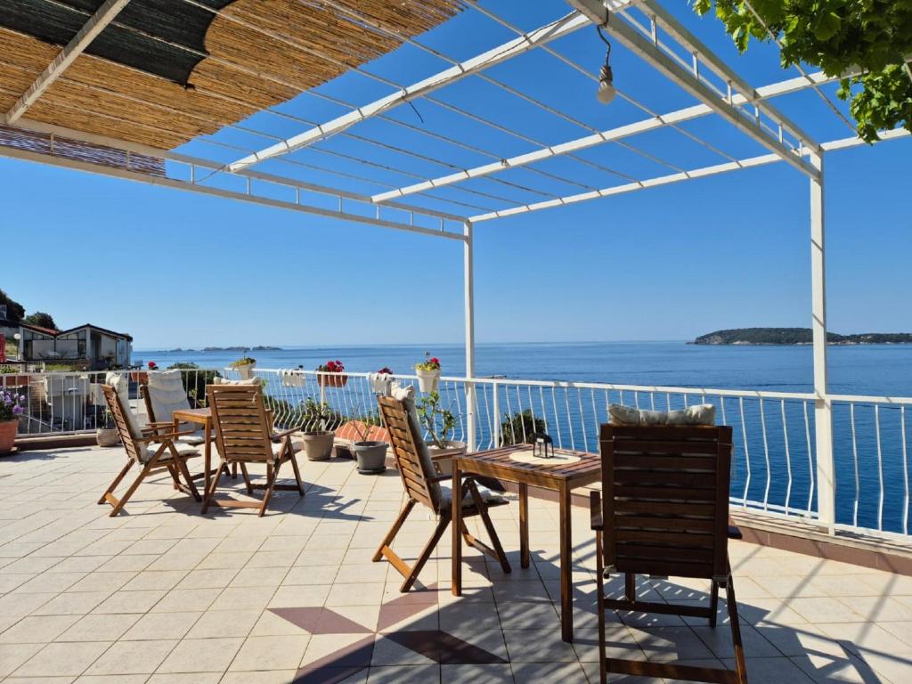 une terrasse avec une table et des chaises et l'océan dans l'établissement Apartmani Matea, à Zaton