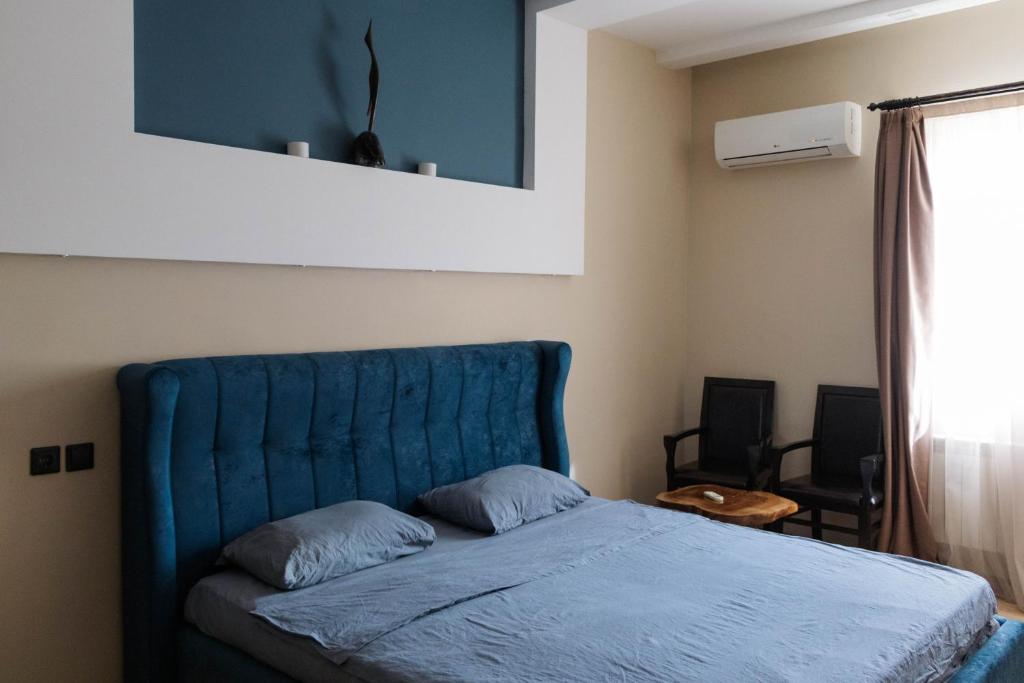Bett mit blauem Kopfteil in einem Schlafzimmer in der Unterkunft Old City Apartment in Baku