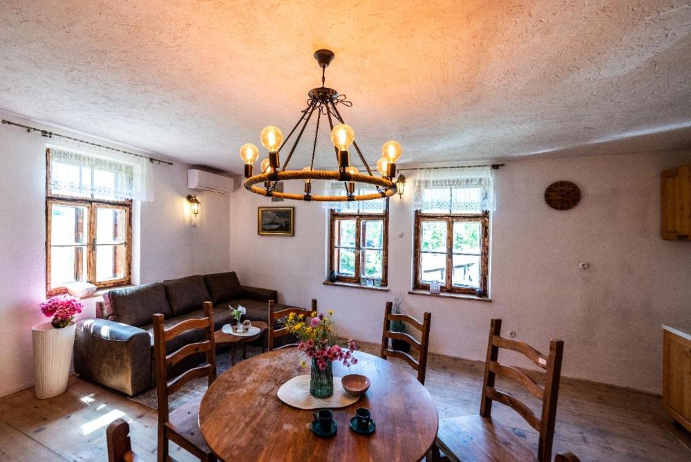 uma sala de estar com uma mesa e um lustre em Hastrmanův Mlýn 