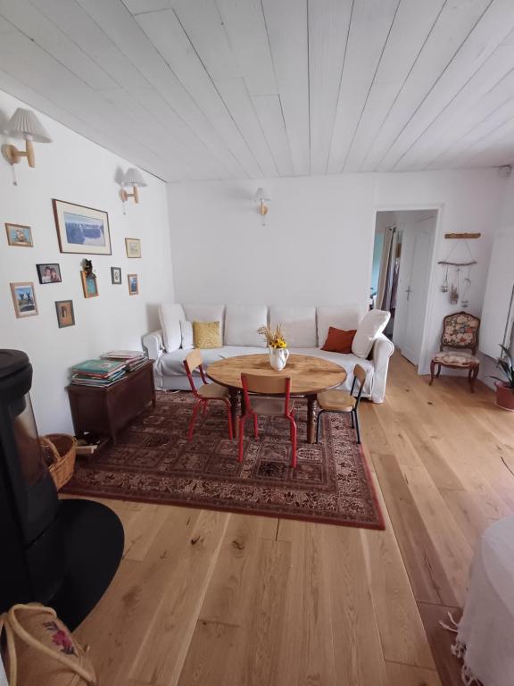 un salon avec une table et un canapé dans l'établissement Maison au calme, à Andernos-les-Bains