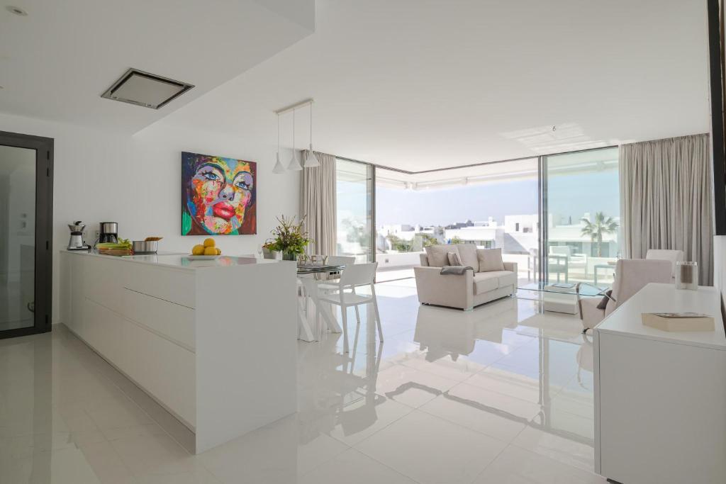 biała kuchnia i salon z blatem i krzesłami w obiekcie Apartment Marbella Golf With Pool - Happy Rentals w mieście Estepona