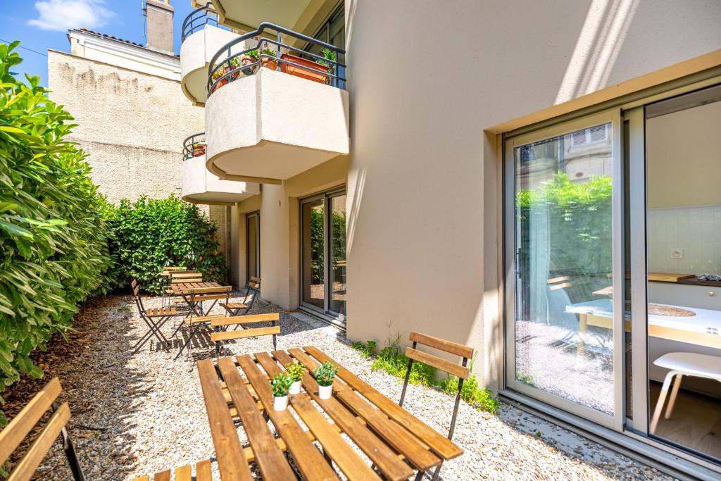 a row of benches sitting outside of a building at Lavie Maison Balneo garden flat in Bordeaux