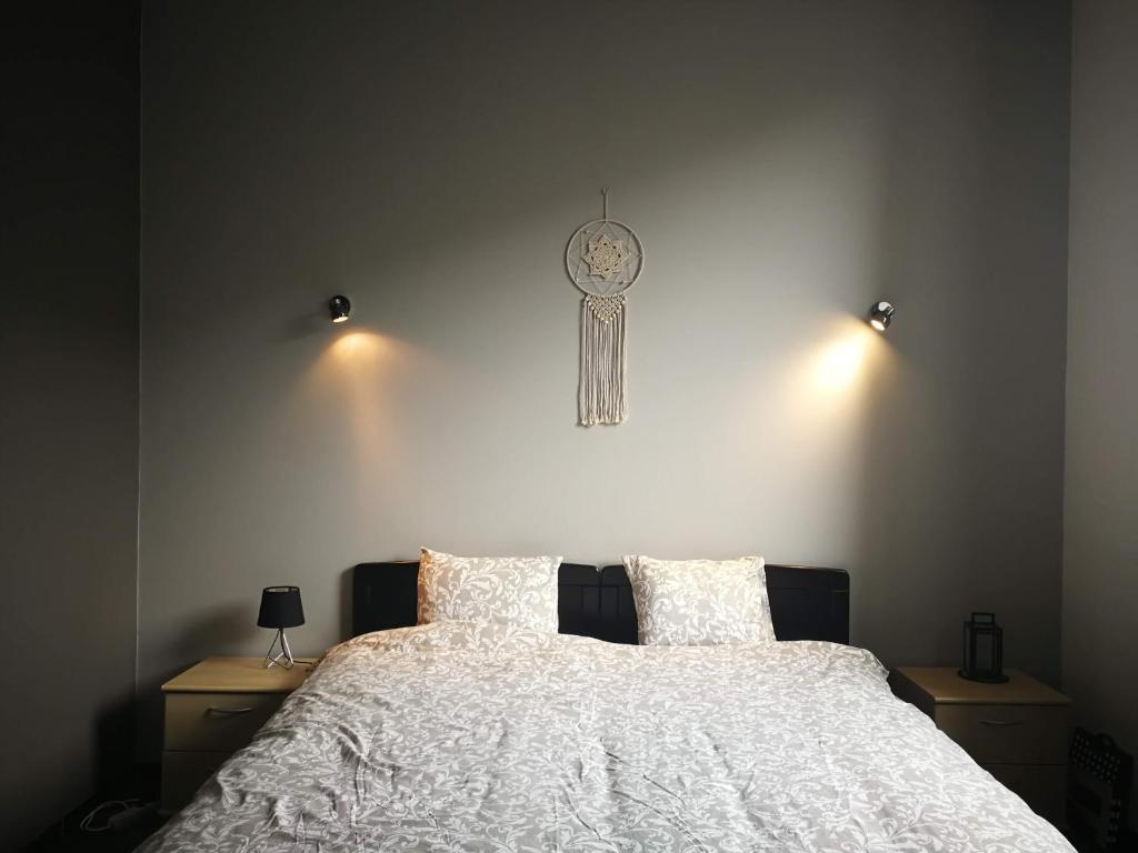 1 dormitorio con 1 cama con reloj en la pared en Mégi des Aguesses, en Andenne