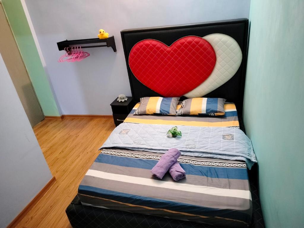 een bed met een hoofdeinde en een paarse teddybeer bij Idea Homestay 1 in Chemor