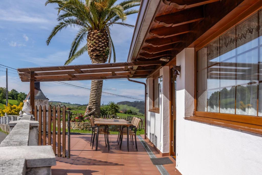 een patio met een tafel en een palmboom bij Casa Rural La Praderia 