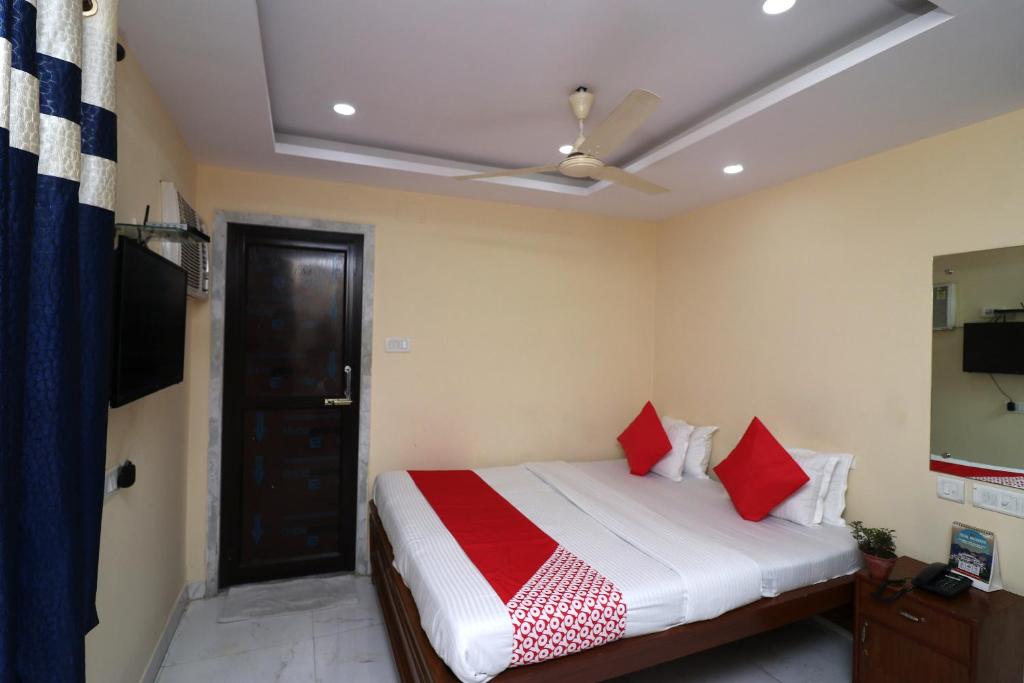 um quarto com uma cama com almofadas vermelhas e um tecto em OYO A G Residency & Son em Bumlitan