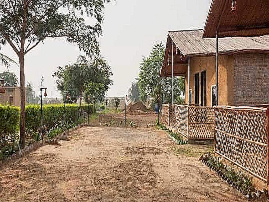 a dirt road next to a house with a fence at POP HOME 80475G Rupani Dhani Adventure in Faridabad