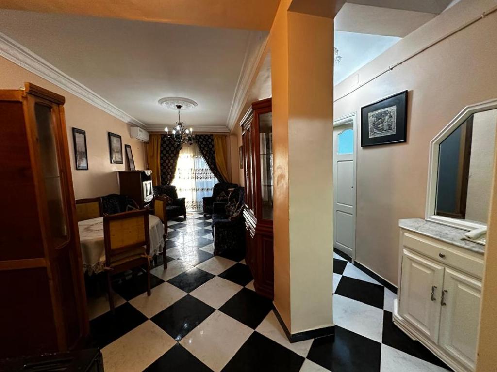 a hallway with a black and white checkered floor at Bel appartement meublé à louer in Fort de lʼEau