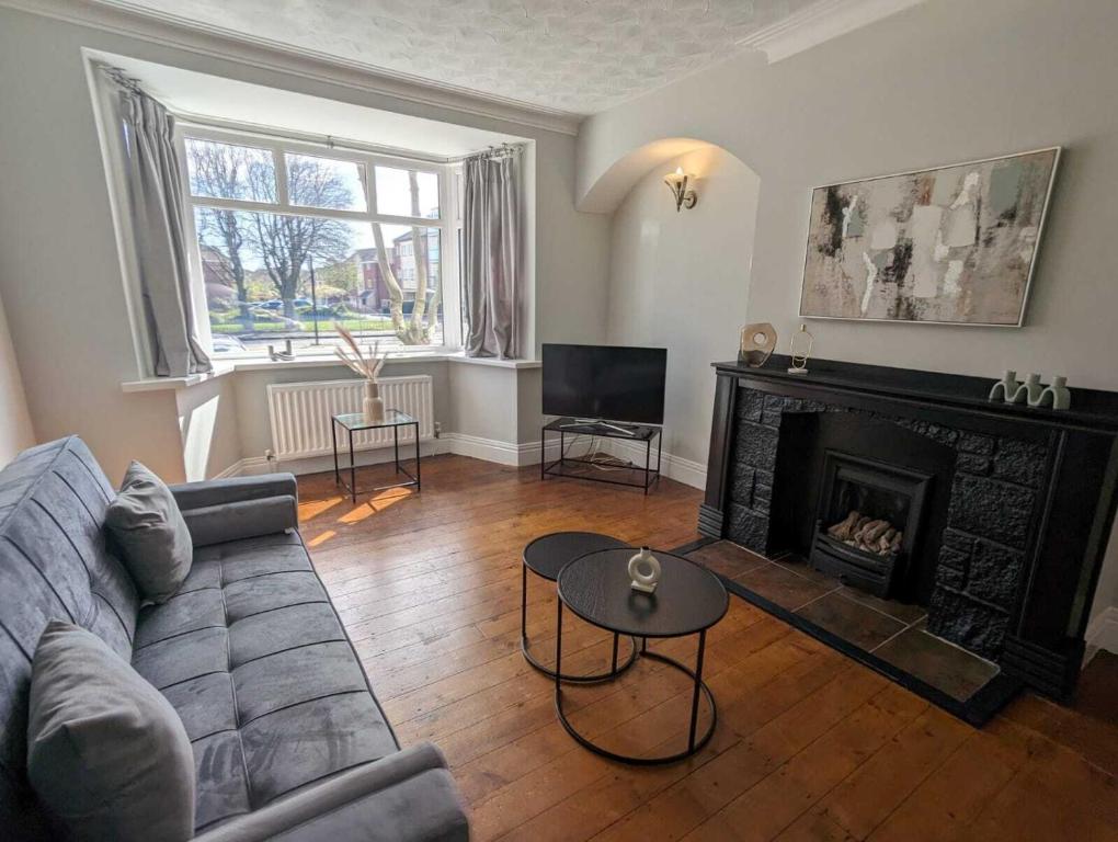 ein Wohnzimmer mit einem Sofa und einem Kamin in der Unterkunft Alexander Apartments Benton Road in Newcastle upon Tyne
