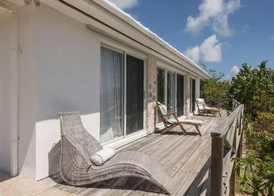una terraza de madera con sillas en una casa en Beachfront Bliss Private Estate with Cottages, en Savannah Sound