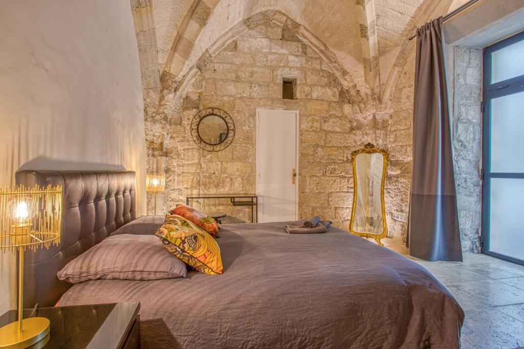 a bedroom with a large bed in a stone wall at La Chapelle du Miracle in Avignon