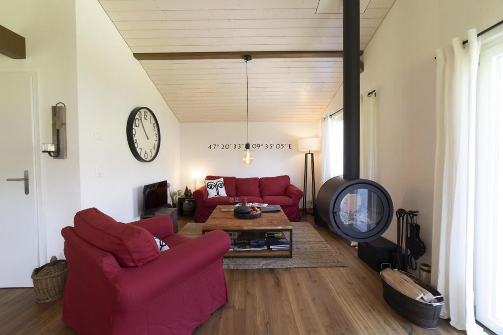 una sala de estar con 2 sofás rojos y una mesa. en Chalet Bergblick en Wildhaus