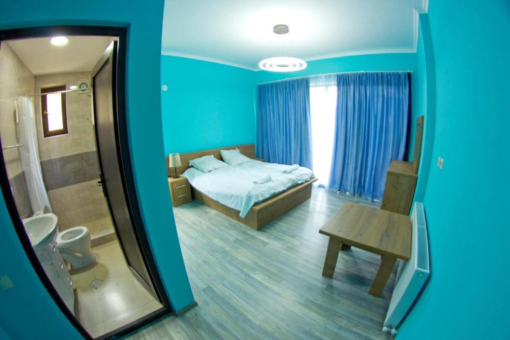 Cette chambre bleue comprend un lit et un miroir. dans l'établissement Aval-Bakuriani, à Bakuriani