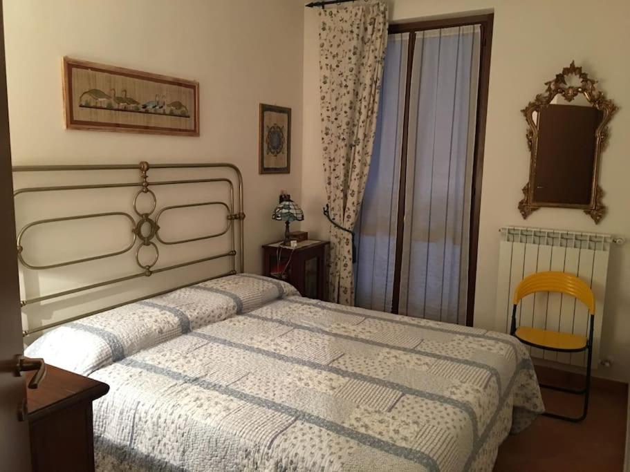 ein Schlafzimmer mit einem weißen Bett und einem Stuhl in der Unterkunft Villino a schiera Abbadia di Montepulciano in Abbadia a Isola