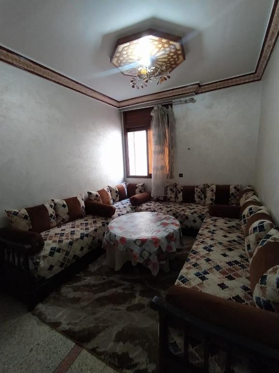 ein Wohnzimmer mit einem Sofa und einem Tisch in der Unterkunft Douaa's home in Rabat