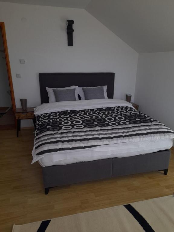 a bedroom with a large bed with a black comforter at Sarajevo Holiday Apartment 3 in Sarajevo