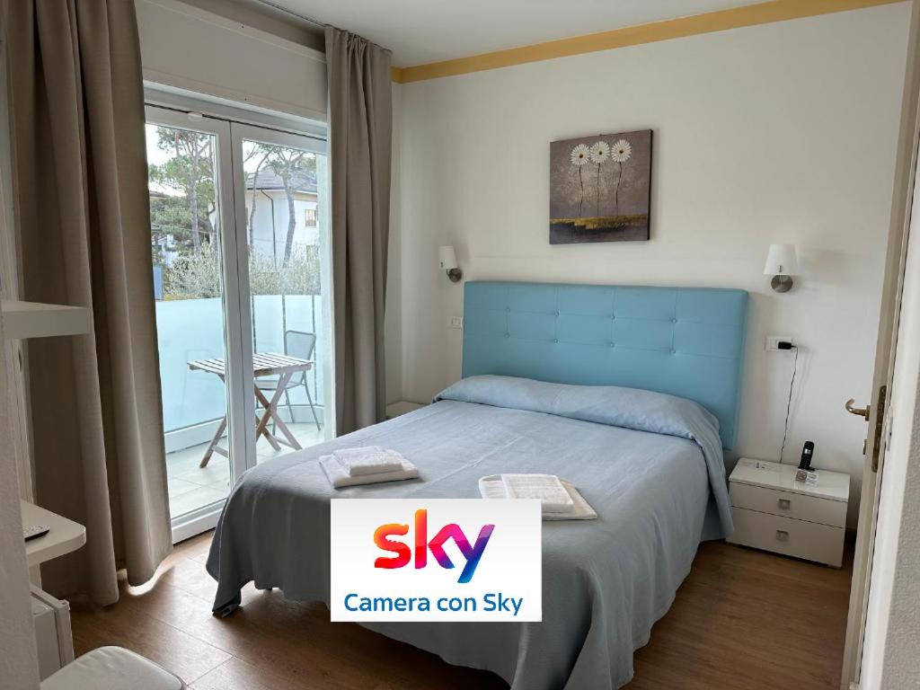 a bedroom with a bed with a sign that says sky at Hotel Irene in Lignano Sabbiadoro