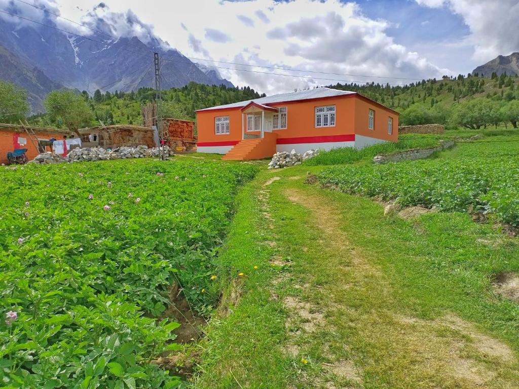 ein Haus mitten auf einem grünen Feld in der Unterkunft Summer Heaven Guesthouse in Tandal