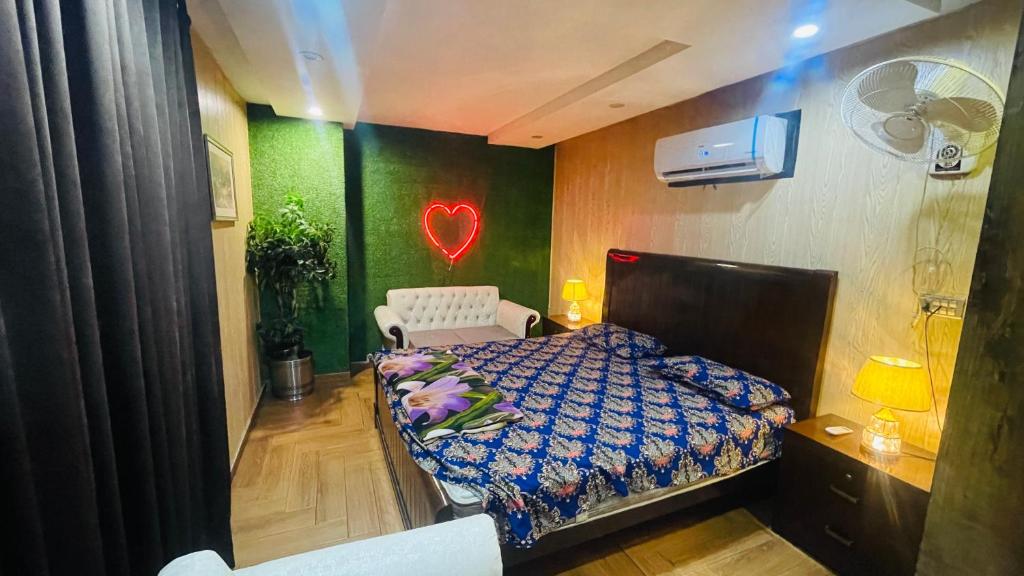 a bedroom with a bed and a heart sign on the wall at Luxury Private Top Floor Apartment in Heart of Bahria Town in Lahore