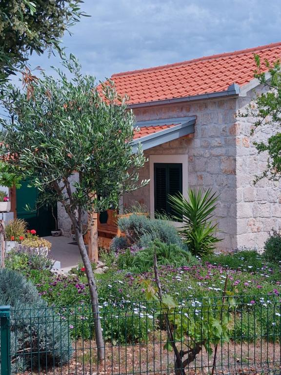 a small house with a garden in front of it at Kuća za odmor Maruška in Mali Drvenik