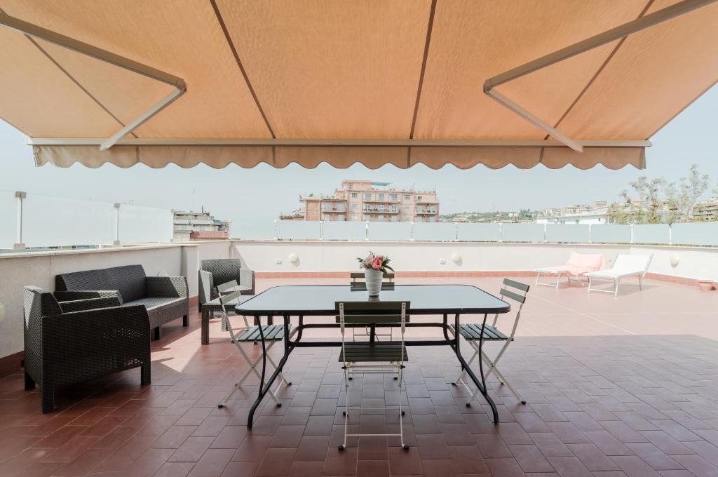 um pátio com uma mesa e cadeiras no telhado em Catania Skyview Terrace: Your Urban Escape em Catânia