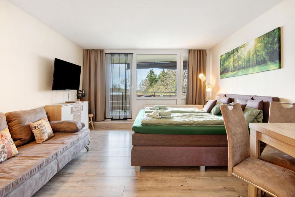 een woonkamer met een bank en een bed bij Ferienappartement Waldgenuss in Sankt Englmar