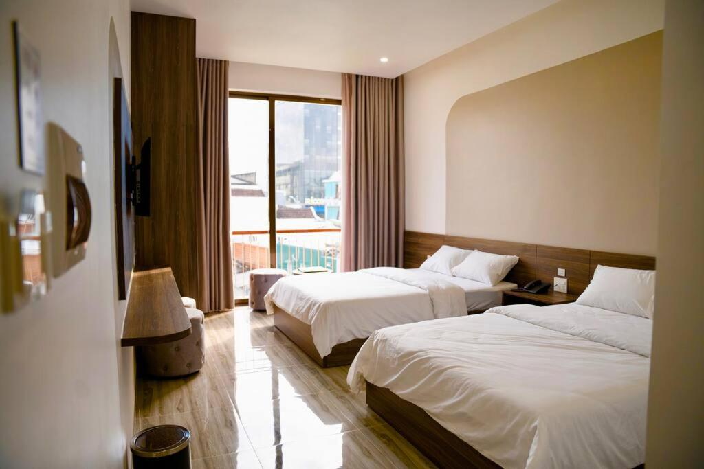 ein Hotelzimmer mit 2 Betten und einem Fenster in der Unterkunft Tuyet Suong Hotel&LoveHouse in Đà Nẵng
