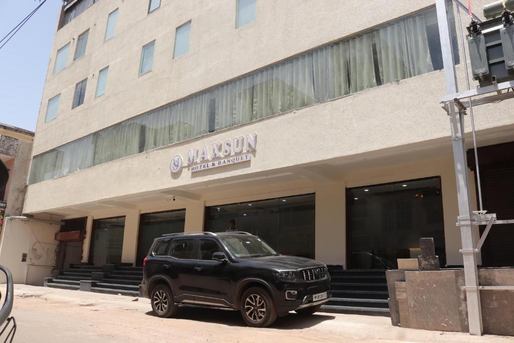 a black car parked in front of a building at Hotel maxsun gwalior in Gwalior