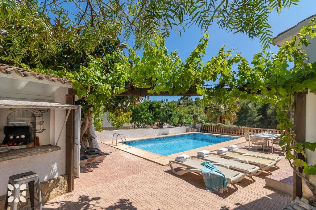 Villa Atmosfera by Abahana Villas في Fanadix: مسبح في ساحة فيها كراسي واشجار