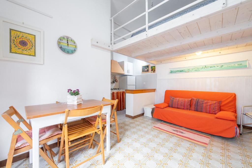 een woonkamer met een oranje bank en een tafel bij Monolocale Ginetto in Calasetta