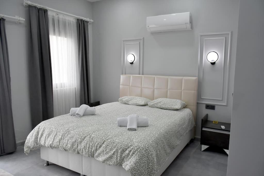 1 dormitorio blanco con 1 cama grande y 2 almohadas en gb’sluxuryhomes Antalya’daki eviniz, en Belek