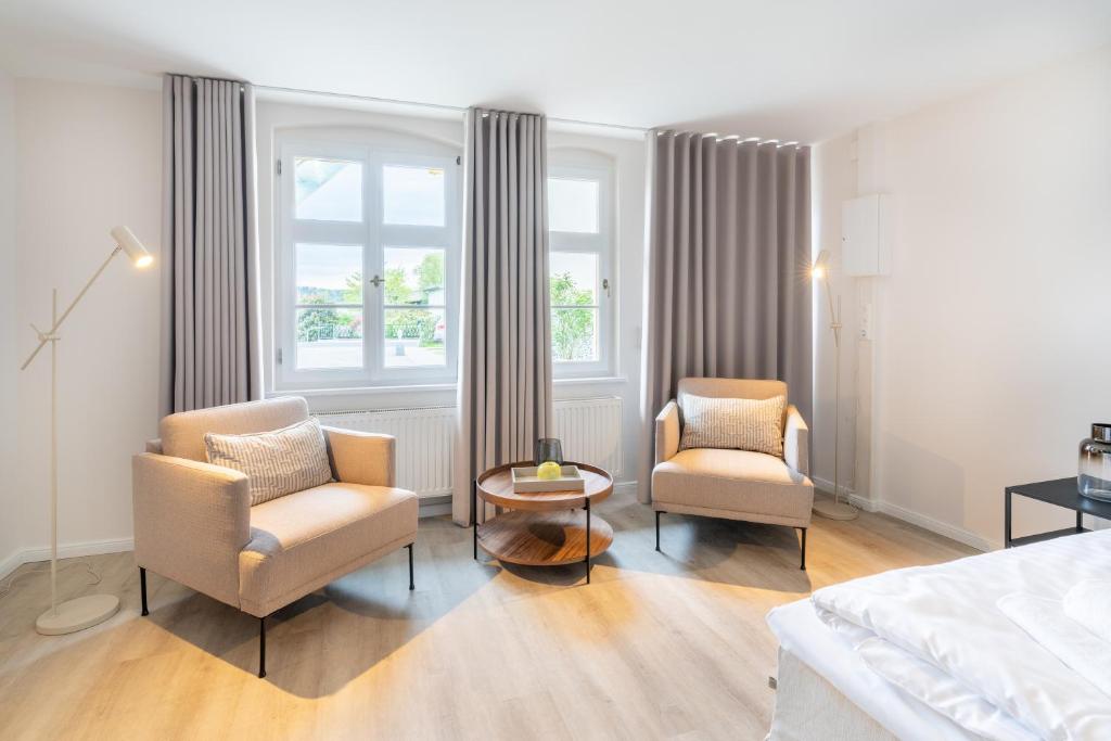 um quarto com 2 cadeiras, uma cama e uma mesa em Villa Albus App 7 em Ahlbeck