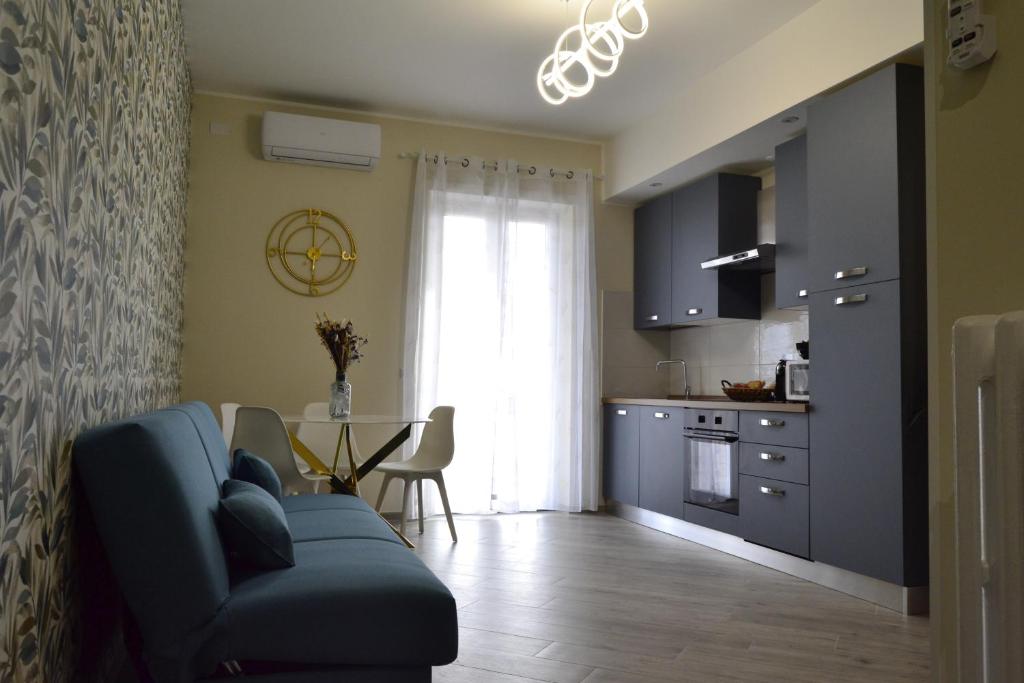 a living room with a blue couch and a kitchen at Green and Blue Apartment in Rome