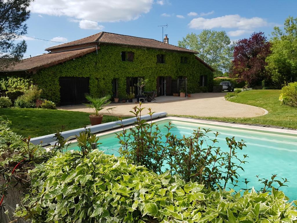 ein Haus mit einem Pool vor einem Haus in der Unterkunft chambre d'hôte la Sourdrie in Saint-Florent-le-Vieil