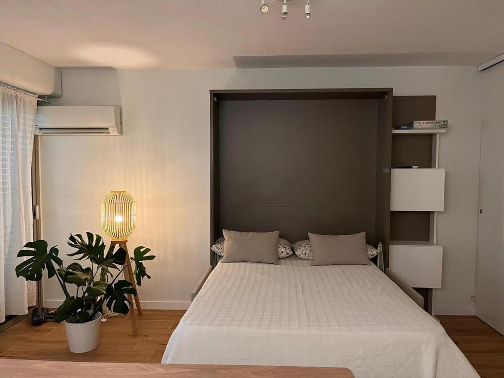 une chambre avec un grand lit avec une grande tête de lit dans l'établissement Beautiful studio - Terrace, à Nice