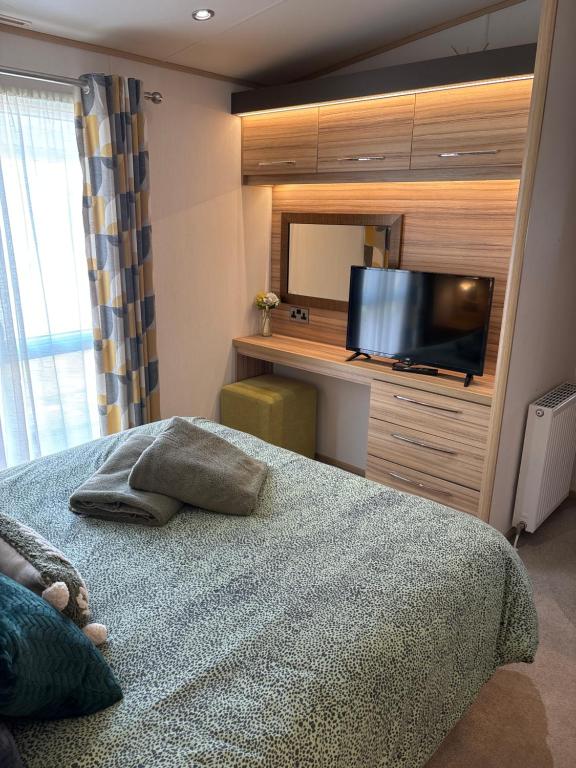 a bedroom with a bed and a flat screen tv at Squirrel Lodge (Unit 7) in Carlisle