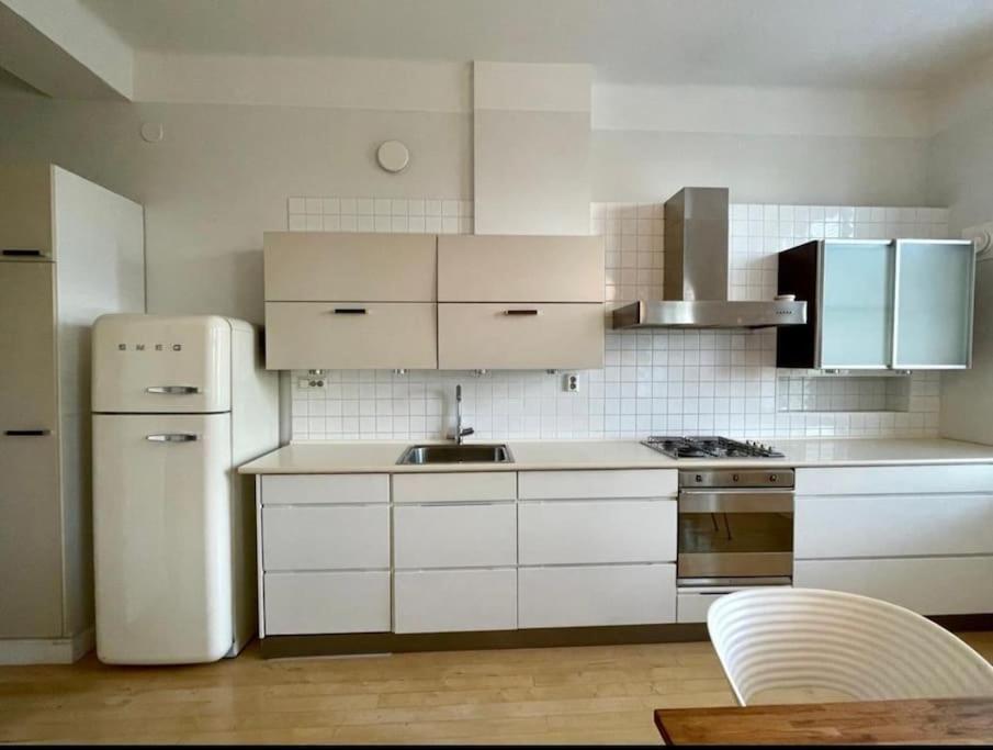 a kitchen with white cabinets and a white refrigerator at Asunto keskustassa, Etu-Töölö in Helsinki