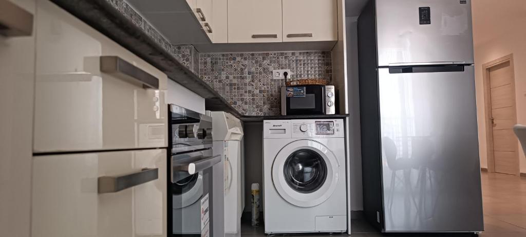 a kitchen with a washer and dryer in a room at Logement Chic, résidence azaléa - Alger in Draria
