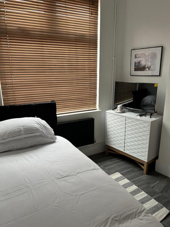 考文垂的住宿－ChaRloHub 01，一间卧室配有一张床、一张书桌和一个窗户。