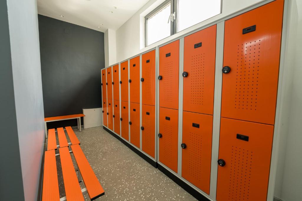 a locker room with orange lockers and a bench at ARCA Resort 