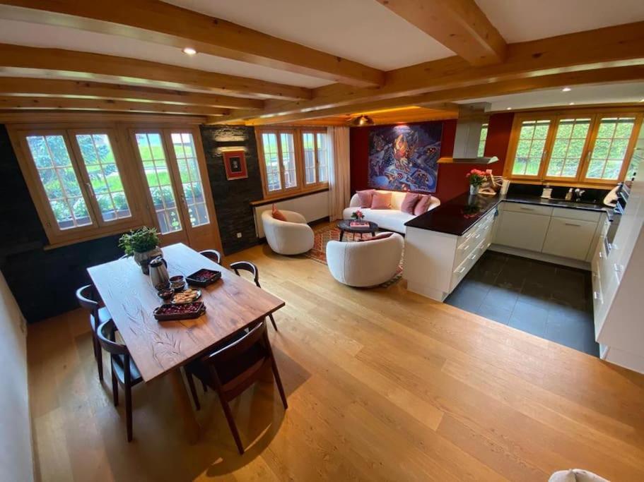 a large living room with a table and a kitchen at Lovely 3 bedroom apartment in Schönried