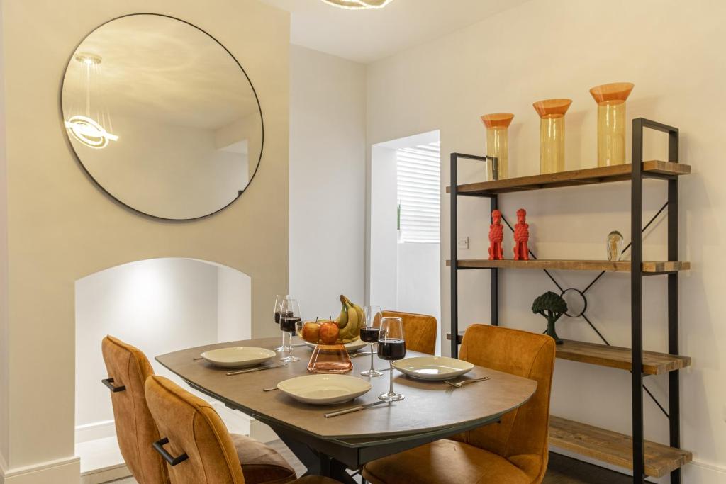 een eetkamer met een tafel met stoelen en een spiegel bij Sparkenhoe House in Hugglescote