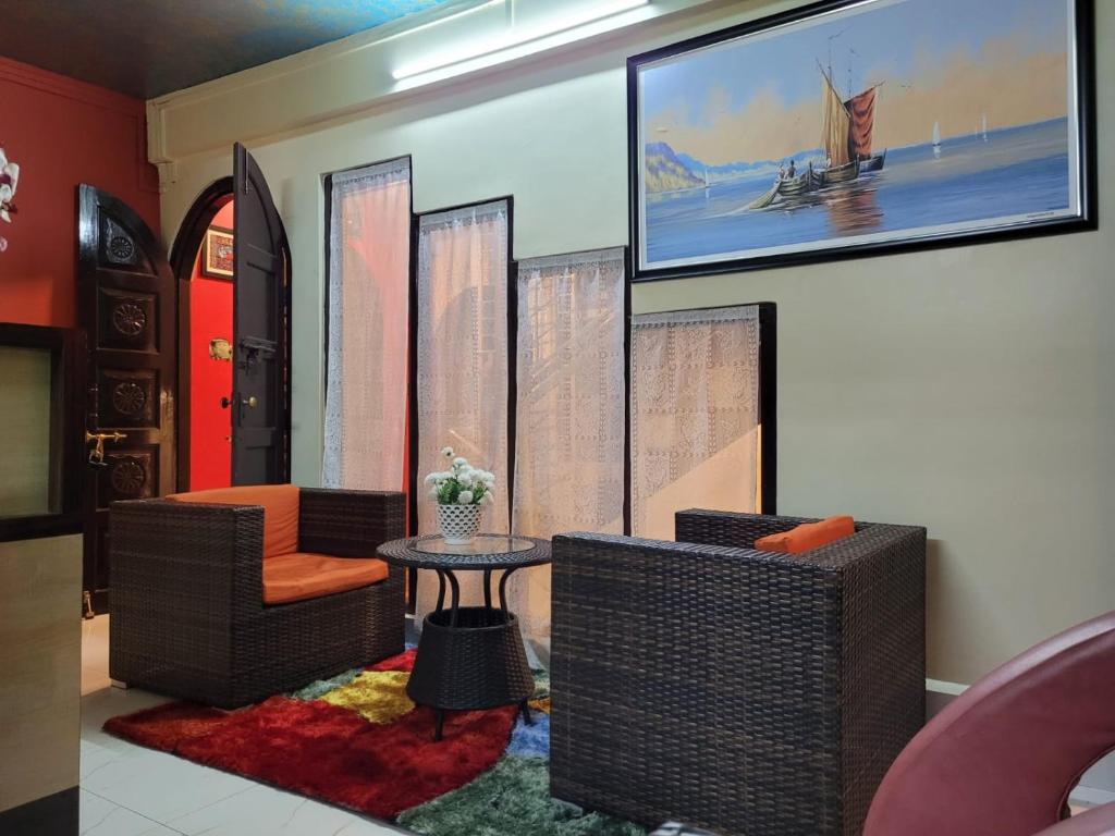 sala de estar con 2 sillas y mesa en Stay Inn Eastwood Guest House, en Shillong