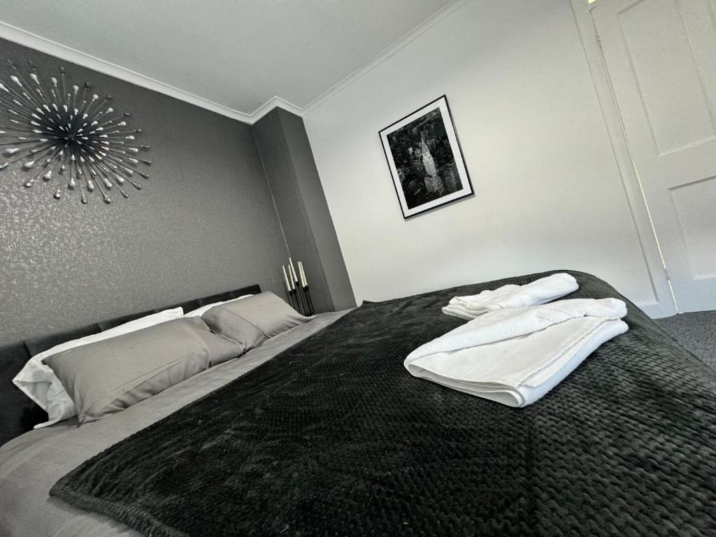 een slaapkamer met een bed met twee handdoeken erop bij Home In Coventry in Coventry