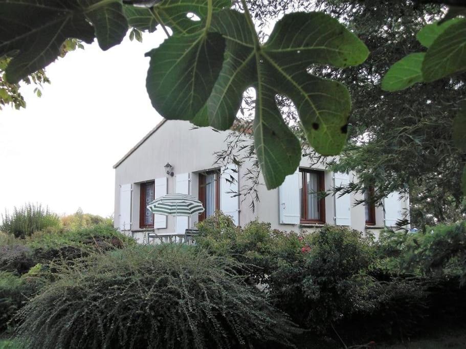 uma casa branca com uma árvore em frente em EN PLEINE VERDURE AU CALME NON LOIN DU CENTREVILLE em La Tranche-sur-Mer