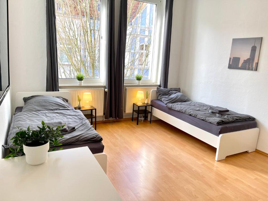 - une chambre avec 2 lits, 2 tables et 2 fenêtres dans l'établissement OS11 - 1-Zimmer Apartment in Osnabrück, à Osnabrück