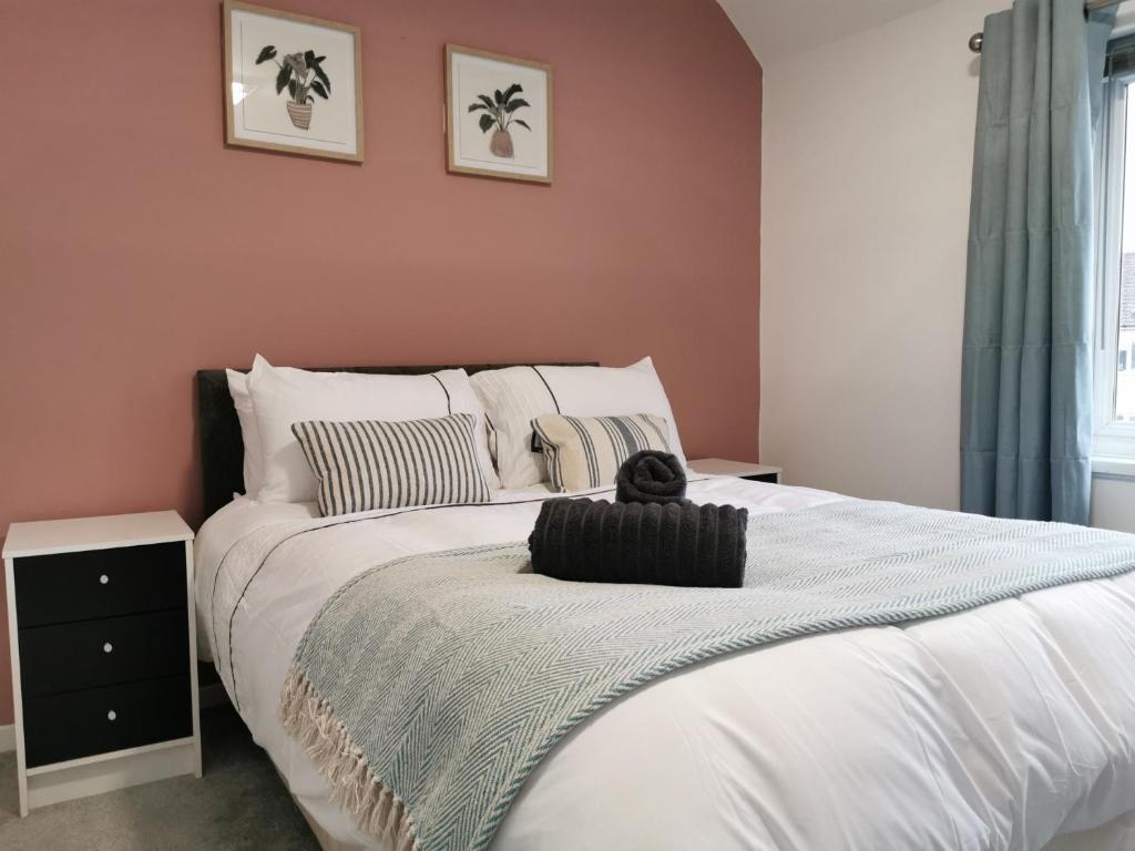 1 dormitorio con 1 cama blanca grande y paredes rosas en Selborne House en Havant