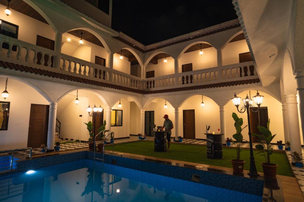 a man standing in front of a pool in a building at Sapphire Mansion in Alibag
