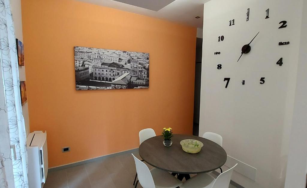 uma sala de jantar com uma mesa e um relógio na parede em unangolodibologna em Bolonha
