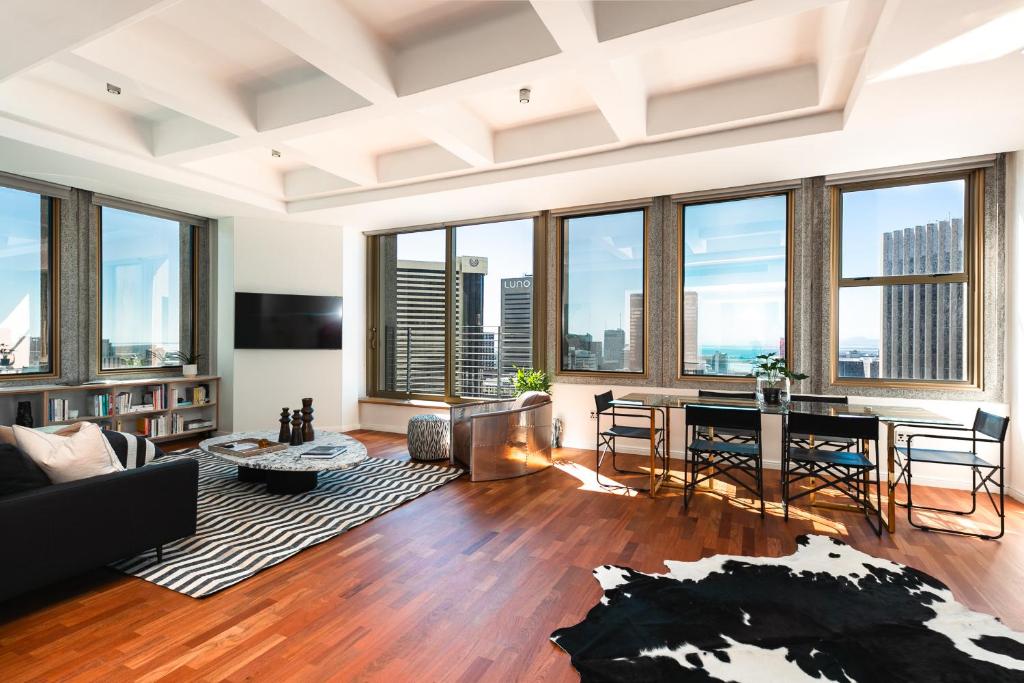 a living room with a table and chairs and large windows at #1905 Cartwright - The Spitfire in Cape Town